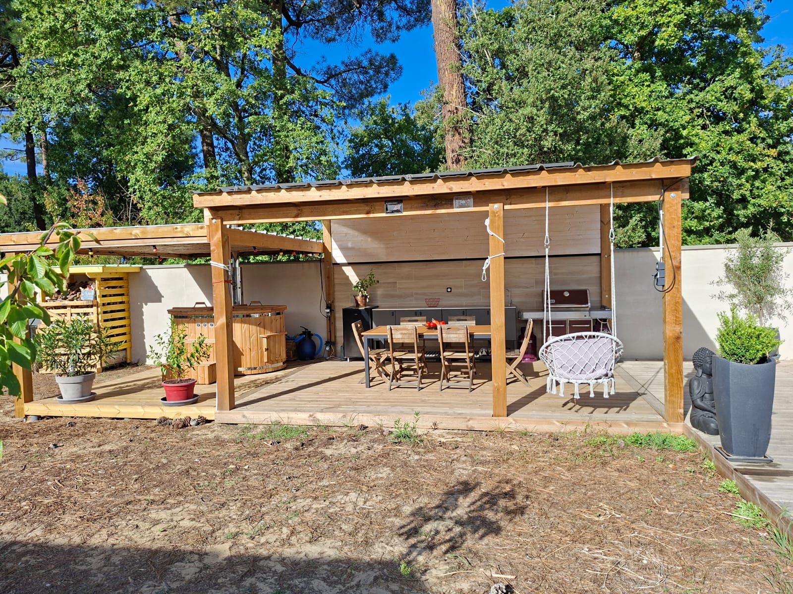 Terrasse en bois des Chambres du Jacuzzi, bain nordique et jardin arboré